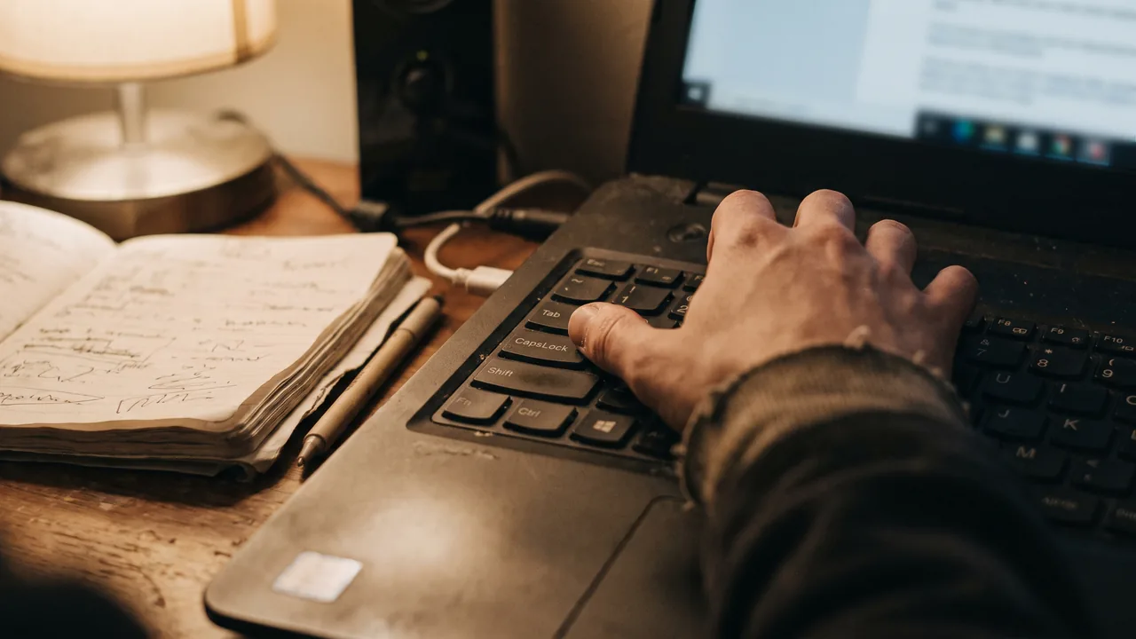 Nahaufnahme einer Laptop-Tastatur, ein Finger ruht auf der Tabulatortaste